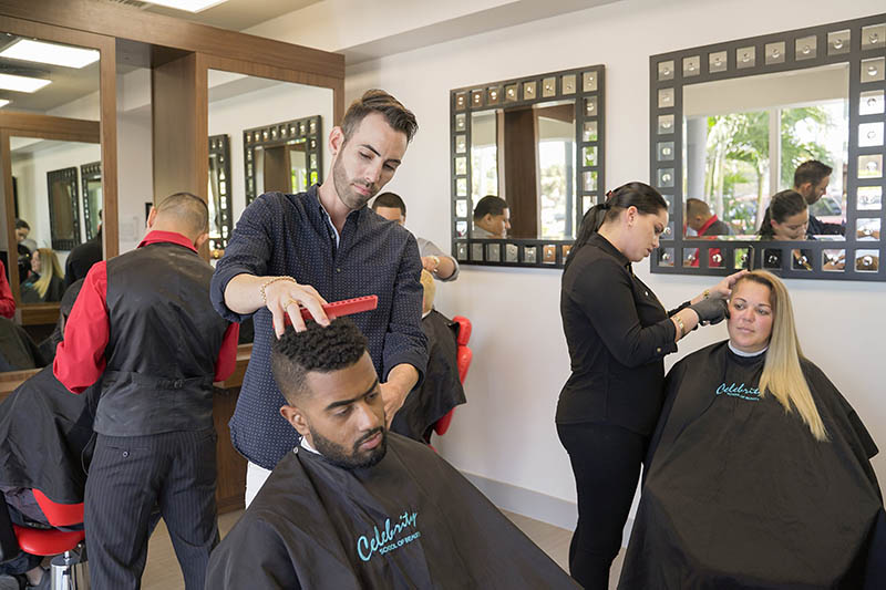 Estudiantes Celebrity Barbería y Cosmetología cortan el cabello de sus clientes en el salón Celebrity.